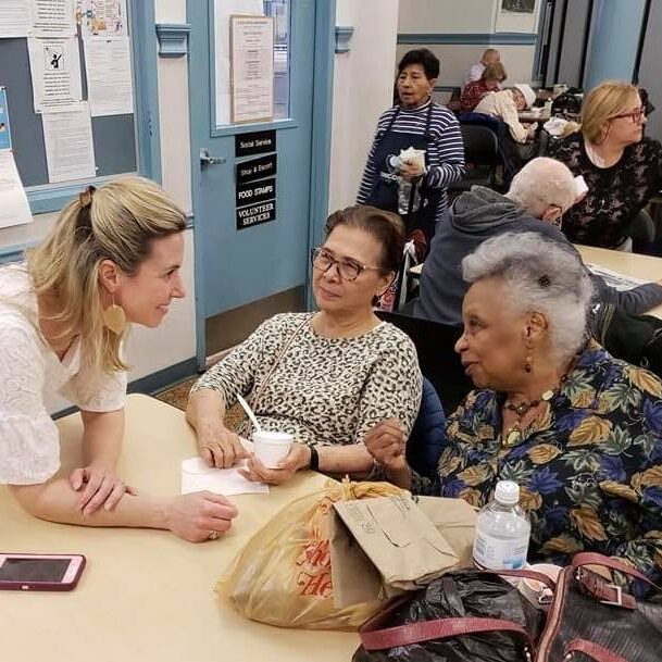 Woman helping older female adults with social services